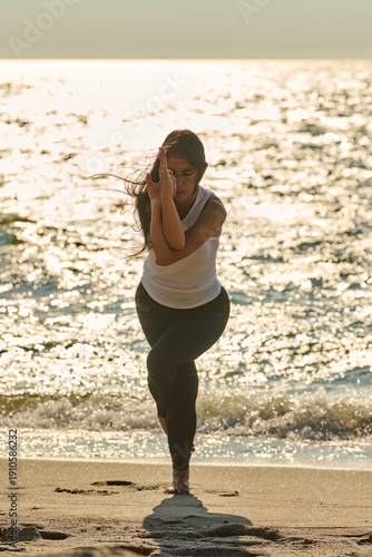 Wallpaper Mural Young woman practicing yoga pose on Baltic Sea beach at sunset Torontodigital.ca