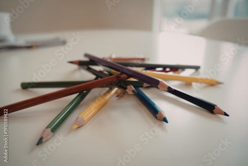 A photo of a set of used color pencils on a white table