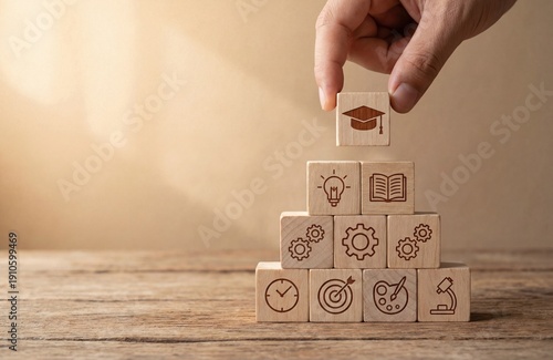 Hand stacking wooden blocks with education icons, representing learning journey, skill development, and academic success concept.