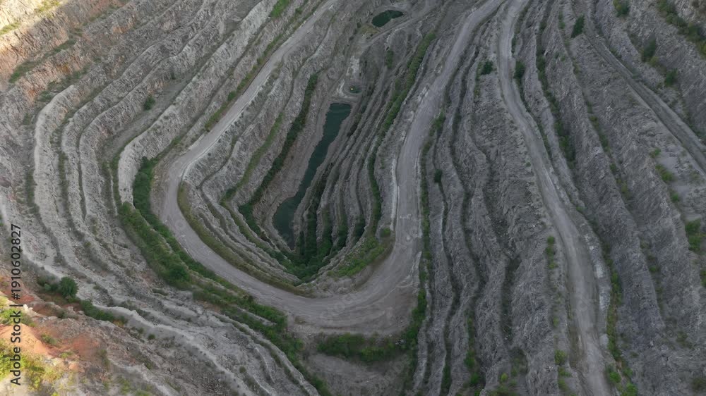 Path Inwards Quarry funnel enclosing elongated water pit with spiraled terraces ...