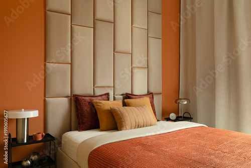 фотографія Modern bedroom interior with upholstered wall and cozy textiles
