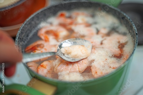 Wallpaper Mural Skimming protein foam from the water surface with a metal spoon while boiling large langoustines. Seafood cooking technique. Torontodigital.ca