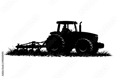 Silhouette of tractor plowing field with farmer in vehicle.