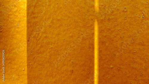 Foto Close-up View of Golden Liquid Surface with Tiny Bubbles and Texture