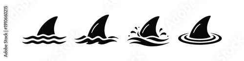 Set of four black shark fins breaking the surface of the water in different styles