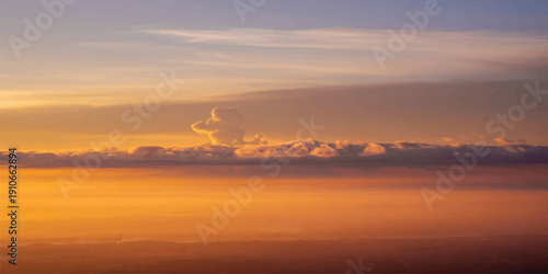 A beautiful orange sunrise and sunset reflection over the river and sea horizon with an oil tanker under a red cloudy sky at dusk