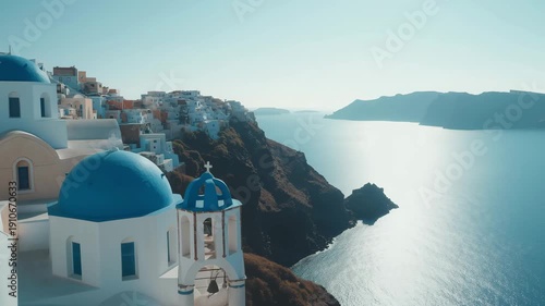 Coastal buildings with blue domes overlook the sea in Santorini, Greece under clear skies during the day