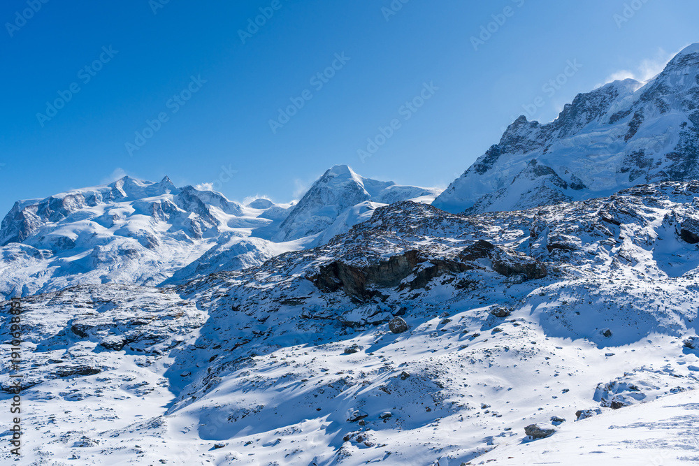 Obraz premium Switzerland winter alpine panorama of snow covered peaks and glaciers above clouds. Zermatt, Canton of Valais, Switzerland. 