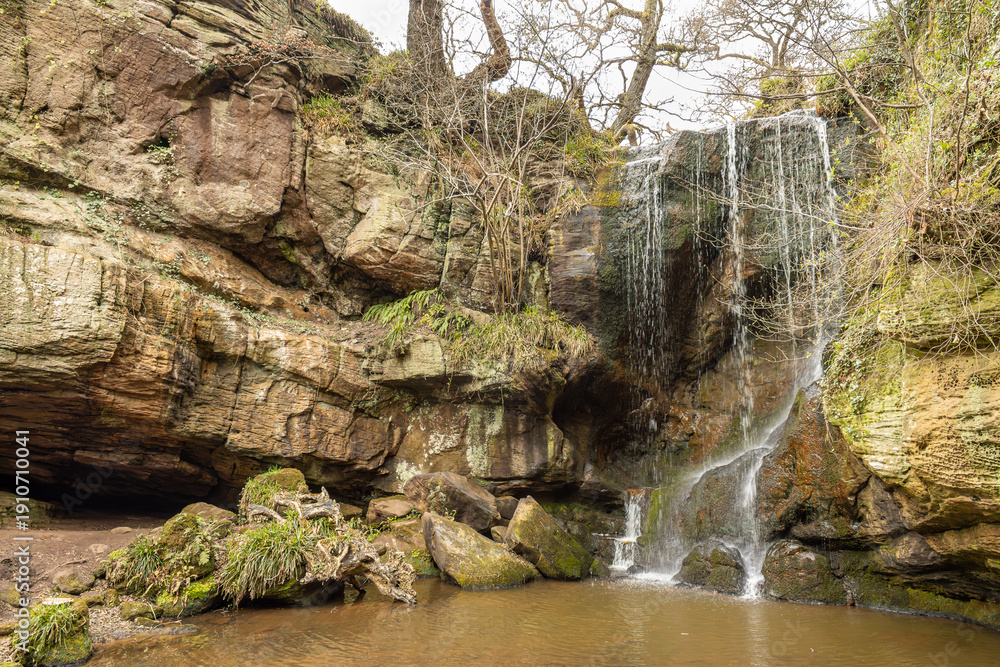 Fototapeta premium Small waterfall over layered rock