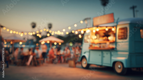 A blue food truck parked at an outdoor festival with string lights