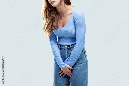 Slika na platnu Young woman pressed her hands to the lower abdomen