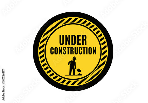 A yellow circular sign with black hazard stripes indicating 'Under Construction' with a silhouette of a worker digging.