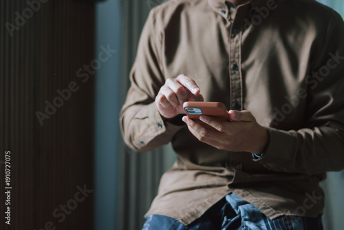 Muslim man using a smartphone for Islamic religious apps and prayer times during Ramadan. Concept of digital faith, connectivity, learning, accessibility, and guidance through mobile technology
