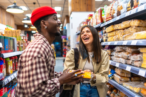 Photos Diverse friends laughing while grocery shopping in supermarket aisle