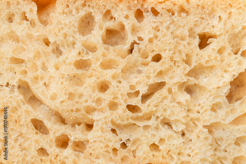 Close-up of sliced ​​piece of whole grain bread. Bread crumb texture, artisan sourdough organic bread macro photography. Food background, bakery products