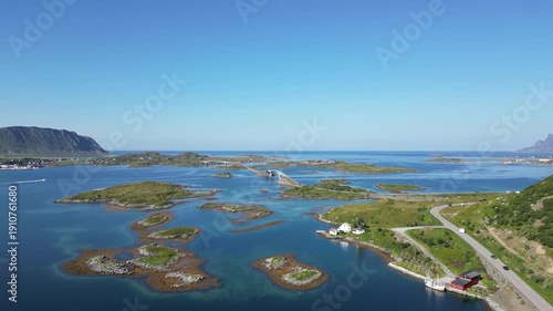 Aerial view of the coastal landscape near Fredvang in the Lofoten Islands of Norway, showing the distinctive Fredvang bridges. The Norwegian Sea is visible in the background.