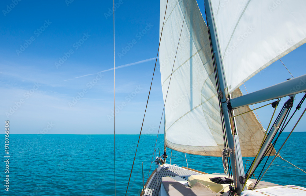 Fototapeta premium Landscape view from bow of luxury sailing boat yacht with detail of main mast and rigging showing blue ocean background