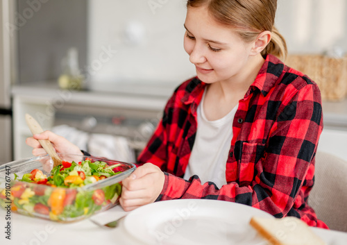 Wallpaper Mural Happy Girl Serving Herself Salad At Home In The Kitchen Torontodigital.ca