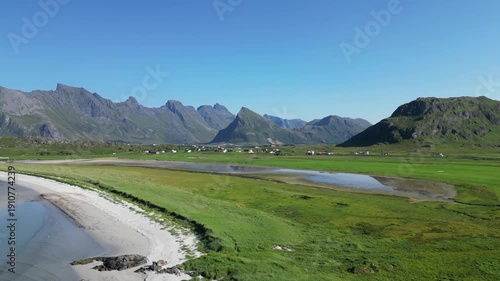 Aerial view overlooking Yttersand Beach with the striking peak of Volandstind in the background.. Fredvang in the Lofoten Islands in Norway.