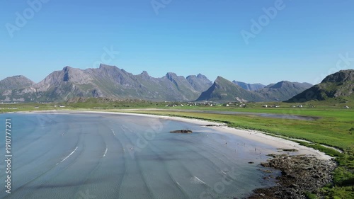 Aerial view overlooking Yttersand Beach with the striking peak of Volandstind in the background.. Fredvang in the Lofoten Islands in Norway.