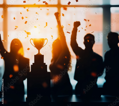 A group of professionals celebrating a corporate achievement, cheering in front of a trophy in a bright office setting.