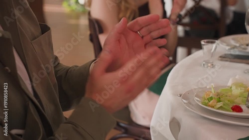 Guests clap their hands at a banquet