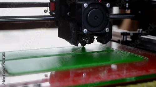 3D printer printing object. 3D printer printing an object from molten plastic on a work surface of 3D printer. 3D printer creating a model. Molten plastic flowing out of an extruder close-up