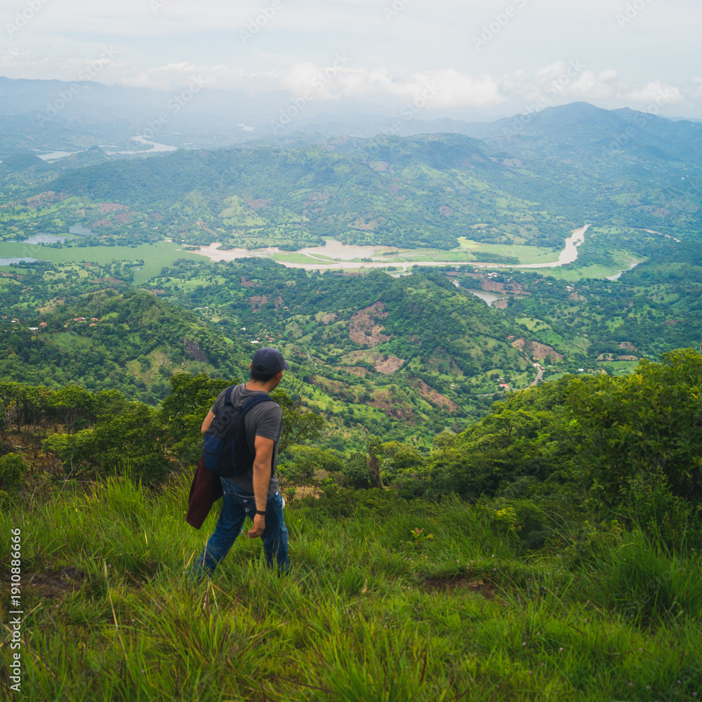 Fototapeta premium Man hiking on Eramon hill in Chalatenango, on a cloudy day
