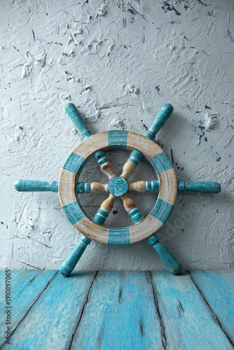 An old wooden steering wheel near a white rough plastered wall