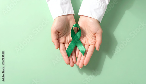 Wallpaper Mural Healthcare professional holding a green awareness ribbon in hands, mental health and medical support concept. Generative AI. Torontodigital.ca