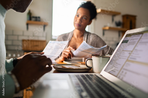 Couple reviewing household bills at kitchen table