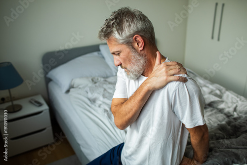 Konstfotografi Older man with shoulder pain in bedroom