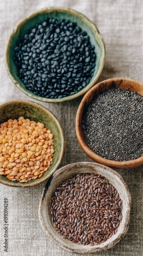 Various bowls of healthy raw seeds and pulses. Chia, flax, black lentil, and red lentil for plant-based nutrition. Vegan diet ingredients.