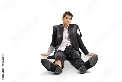 Foto Man in a ruined suit sitting on the floor
