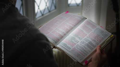 man reading bible in morning window light doing devotions