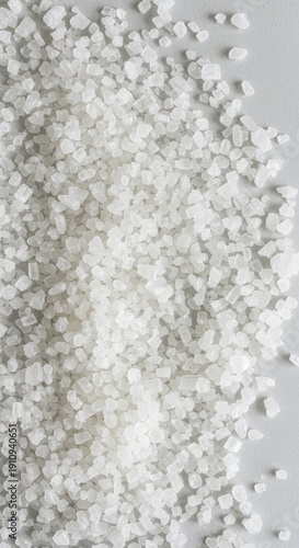 Close up of white sea salt crystals covering a bright white surface. Natural, high-key food background texture ,culinary ,grit ,dry