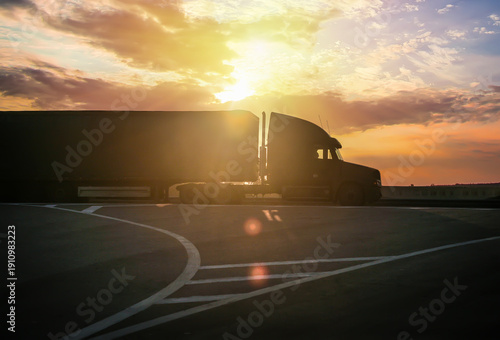 Truck drives down the road at sunrise.