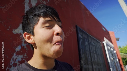 Hispanic teenager eating a delicious mexican street food taco
