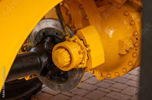 Принти на полотні Close-up of a heavy-duty truck axle and disc brake system on yellow industrial machinery