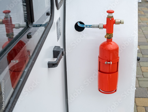 Foto Close-up of a red fire extinguisher cylinder mounted on a white industrial vehicle