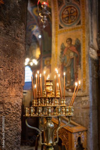 Foto Burning candles in an Orthodox church, golden candlestick in a temple