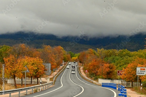 Foto A secondary road cuts through the late autumn landscape and leads the eye to the mountain in the distance