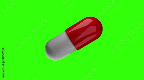 A 3d rendered medical capsule pill with a glossy red and white finish rotating in a continuous loop. The pharmaceutical object is isolated on a bright green chroma key background