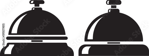 Two vintage hotel reception desk bells, one slightly pushed, symbolizing service and attention