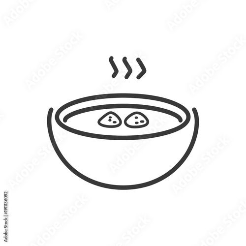 A bowl containing steaming soup with two floating dumplings in it