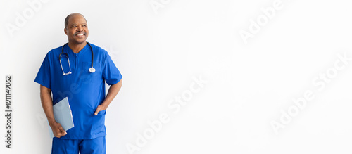 Cuadro en lienzo Mature black male doctor in blue scrubs holding clipboard and looking aside with