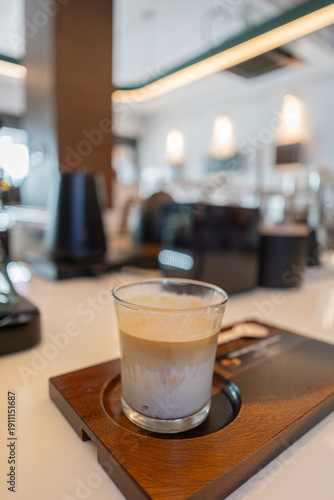 Cold dairy coffee drink with milk, whipped cream. Foamy frappe, latte, cappuccino, on a coffee shop background, space for text. Summer cold coffee cocktail