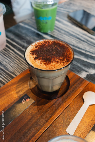 A cup of cappuccino on the wooden table at coffee shop, from above.