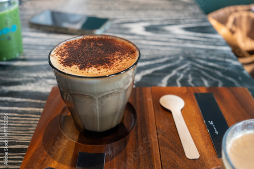A cup of cappuccino on the wooden table at coffee shop, from above.