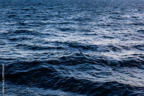 Ocean surface texture top view wavy deep blue reflective abstract, pattern photo.